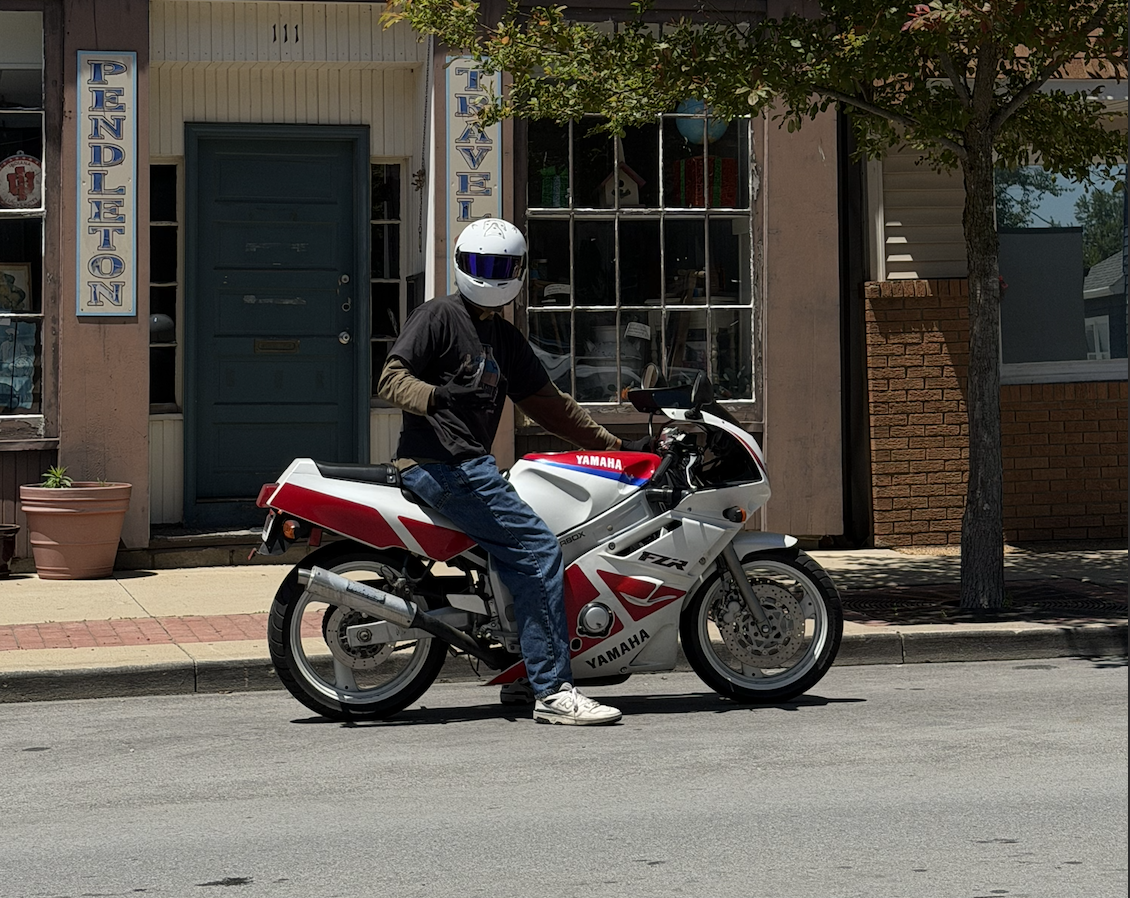 Nolan sitting on a white, red, and blue 1991 Yamaha FZR600R on a street.