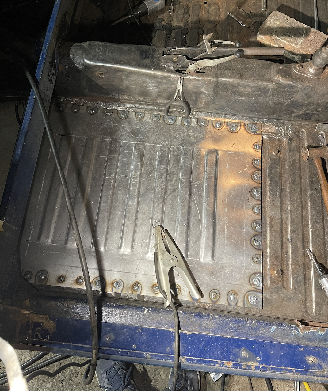Custom fabricated Karmann Ghia floor pan being welded into place.