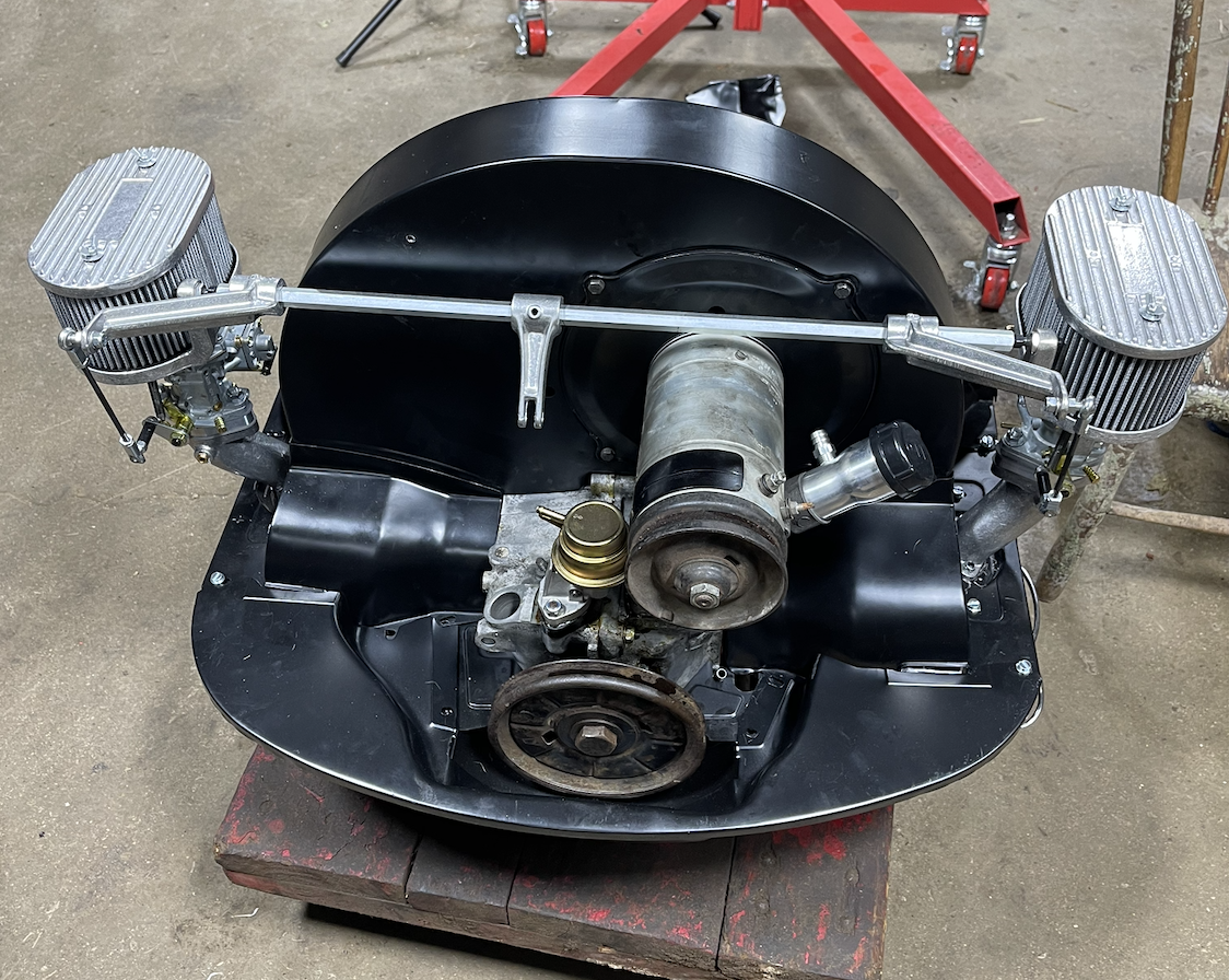 Rebuilt Volkswagen flat-four engine with dual carburetors assembled on a workbench.